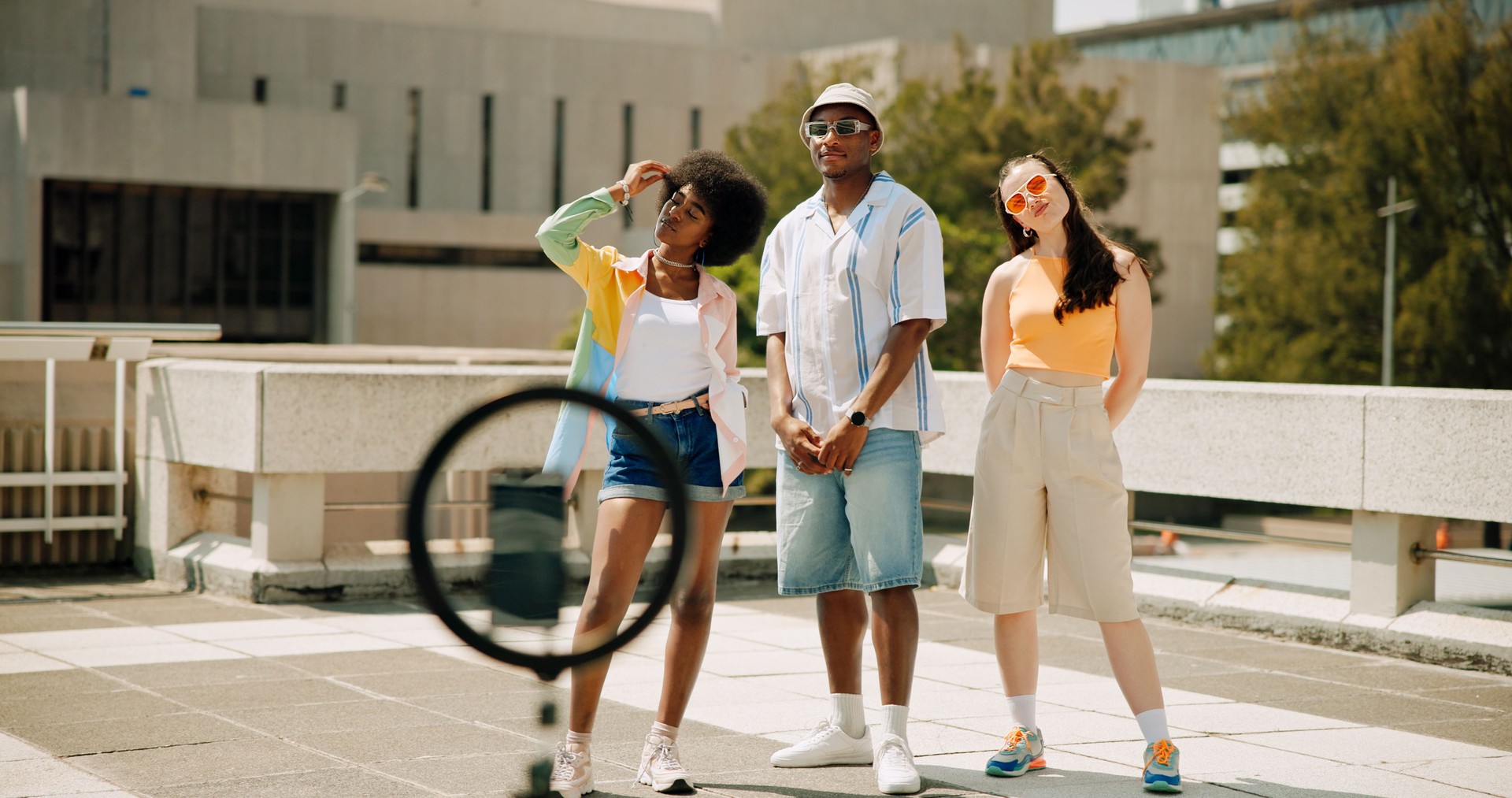 Group, friends and cool with influencer, outdoor and live streaming with ring light, fashion and smartphone. Roof, people and content creation for social media, digital and trendy with outfit